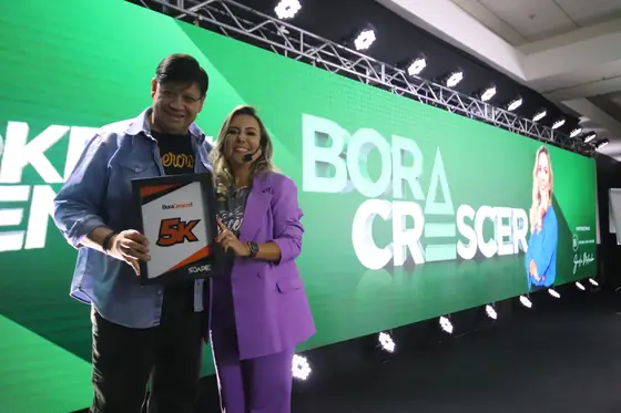 Placa 5K entregue por Aline Soaper no palco do evento Bora Crescer